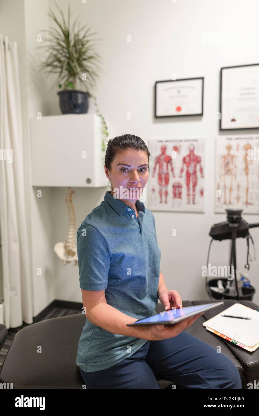 Porträt eines Physiotherapeuten mit digitalem Tablet im Behandlungsraum Stockfoto