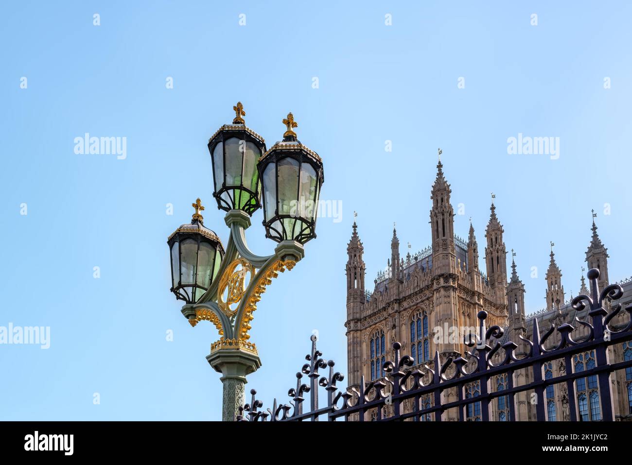 Dekorative Straßenlaternen und schmiedeeiserne Geländer außerhalb des Houses of Parliament, London, Großbritannien. Blauer Himmel mit Platz für Text. Stockfoto