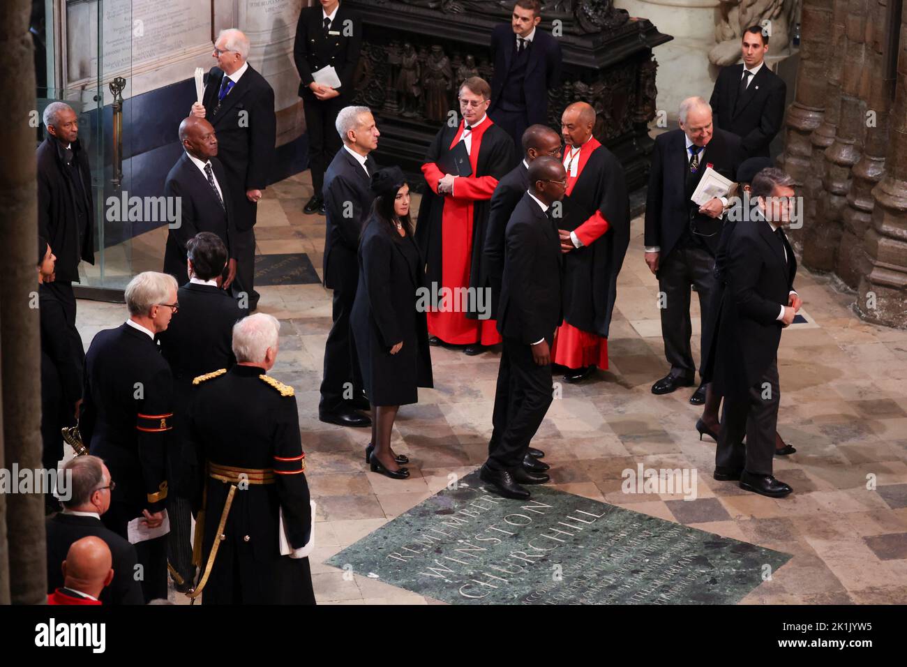 Mitglieder des Klerus begrüßen die Gäste, die am State Funeral of Queen Elizabeth II in Westminster Abbey, London, ankommen. Bilddatum: Montag, 19. September 2022. Stockfoto