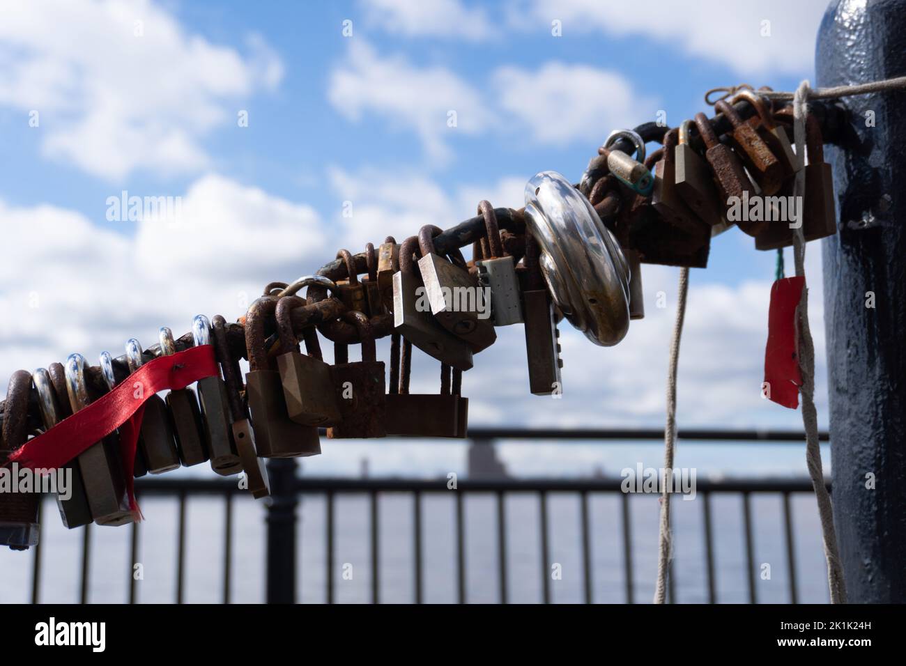 Nahaufnahme einer Reihe von Metallschlössern an einer Kettendockseite im Hintergrund Stockfoto
