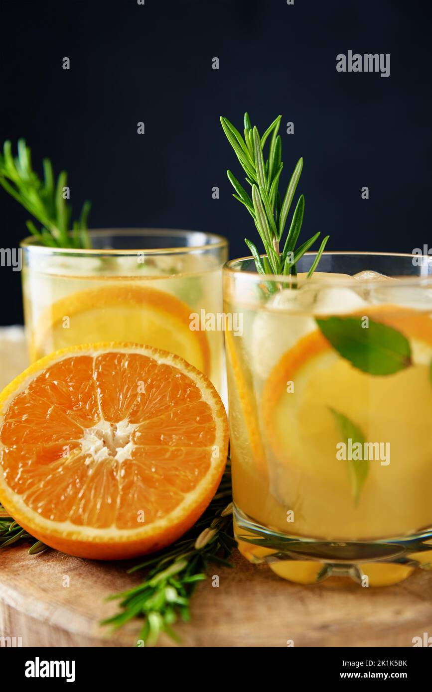 Hausgemachte Limonade mit Orange und Rosmarin, ein Glas Sommercocktail auf dunklem Hintergrund, Citrus Detox-Wasser zur Erfrischung an heißen Sommertagen Stockfoto
