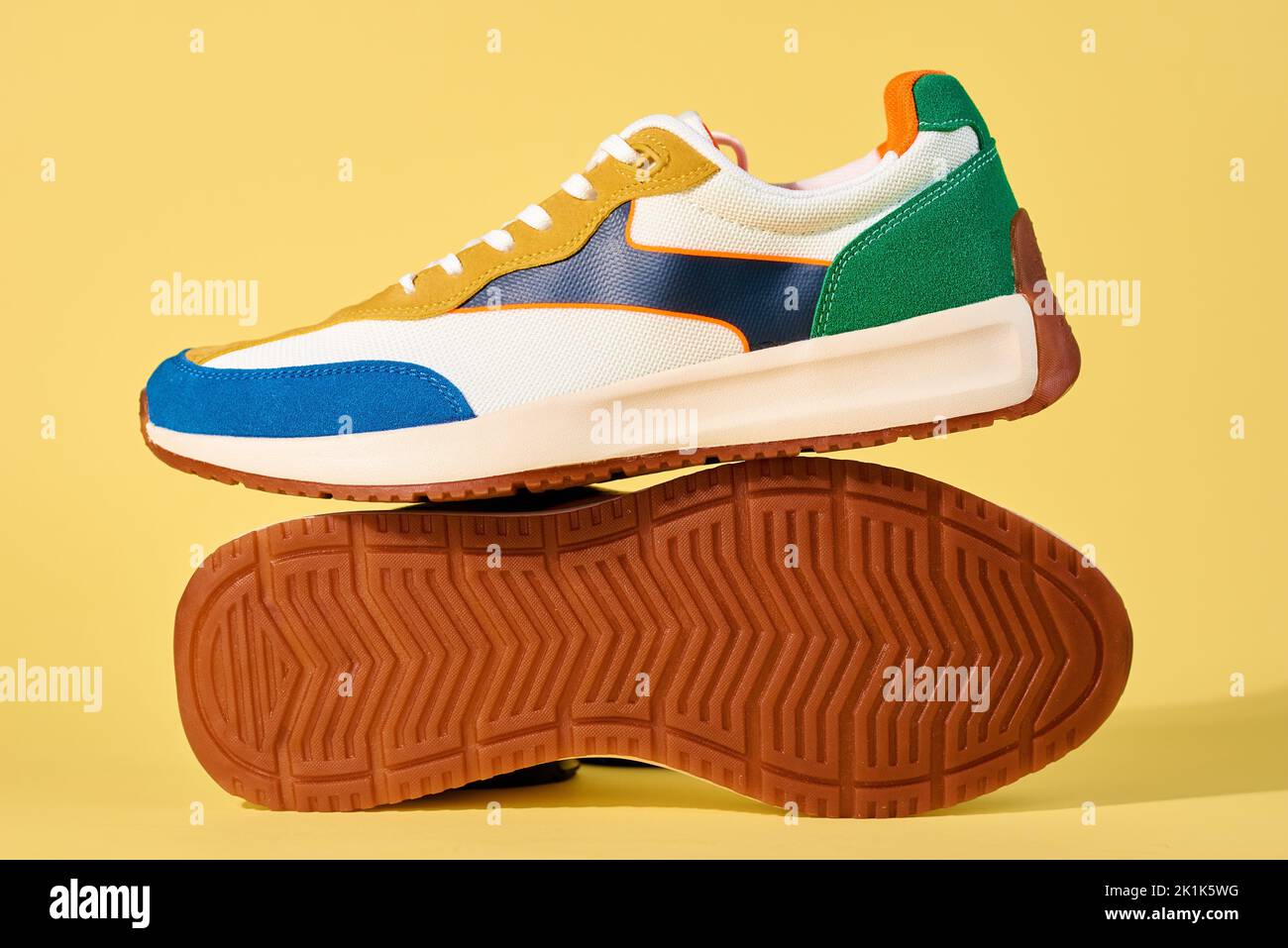 Modische Schuhe auf gelbem Hintergrund. Sport-Sneaker mit Copy Space, sommerliches Schuhkonzept Stockfoto