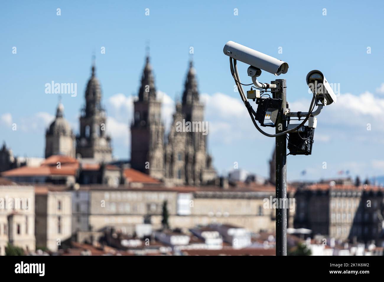 Die Szene der Sicherheitskameras auf der Stange und der Kathedrale von Santiago de Compostela verschwommen im Hintergrund. Überwachung des Stadtkonzepts von Santiago de Compostela Stockfoto