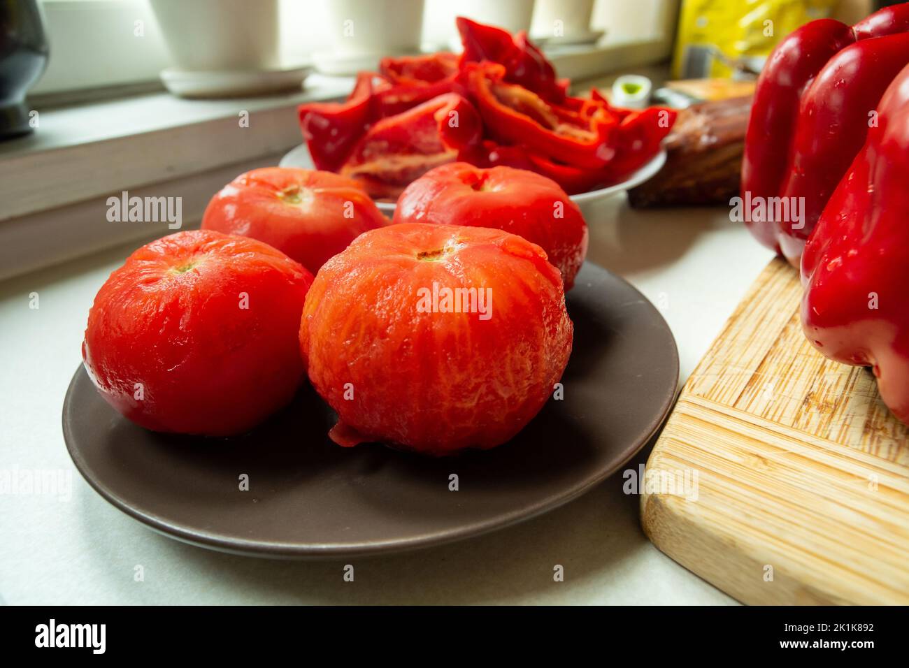 Gebrühtes, geschältes frisches rotes Tomaten auf einem Teller als Zutat Stockfoto