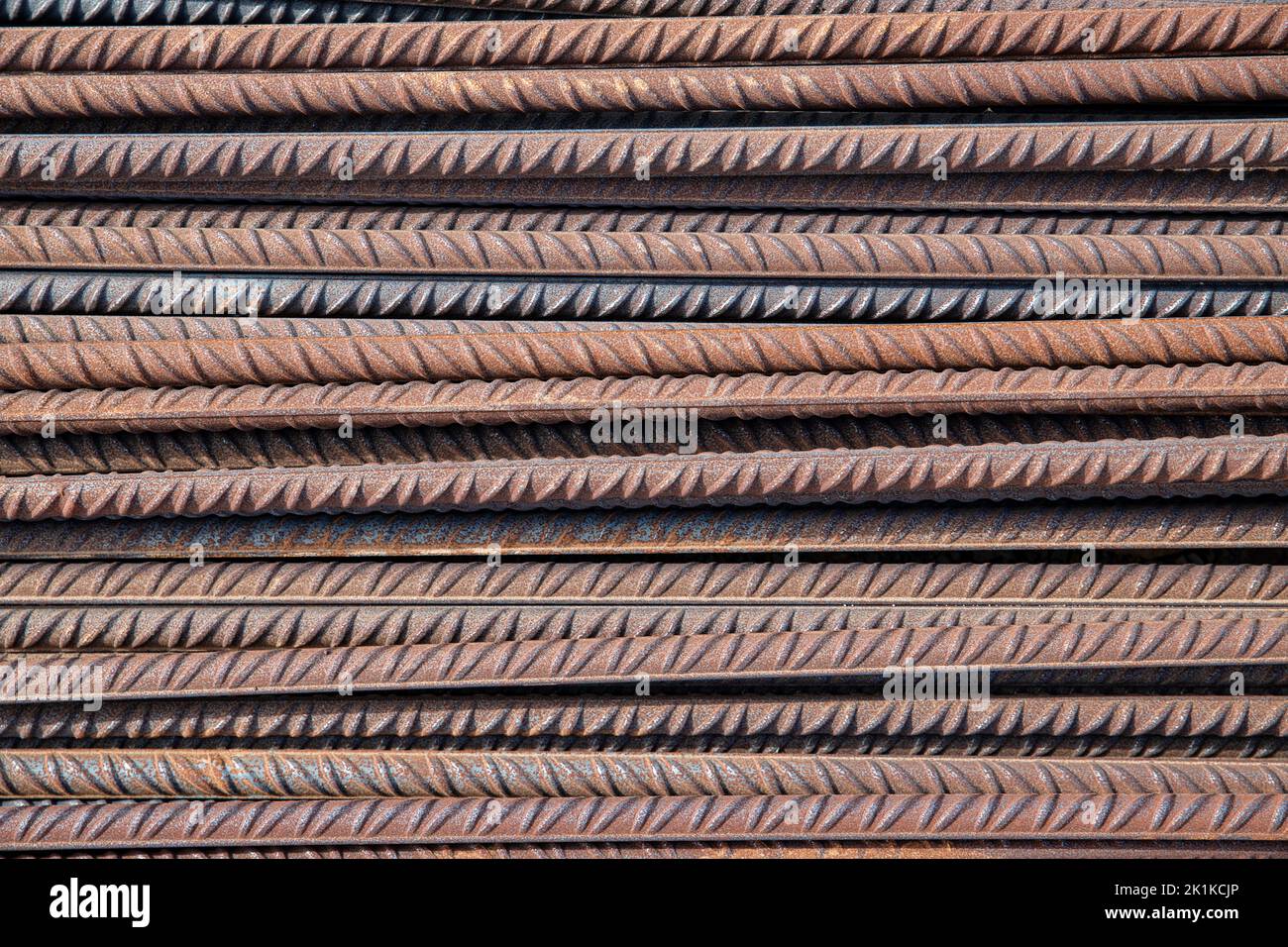 Stapel von Stahlstäben, auch bekannt als Riegel, als Baumaterial in Betonbetonarbeiten oder Mauerwerk verwendet, Nahaufnahme der rostigen Stäbe Stockfoto