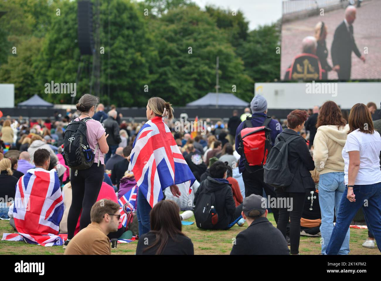 Staatsbegräbnis Ihrer Majestät Königin Elizabeth II., London, Großbritannien, Montag, 19.. September 2022. Menschenmassen im Hyde Park, um die Zeremonie auf einem großen Bildschirm zu sehen, einige in Gewerkschaftsflaggen gewickelt. Stockfoto