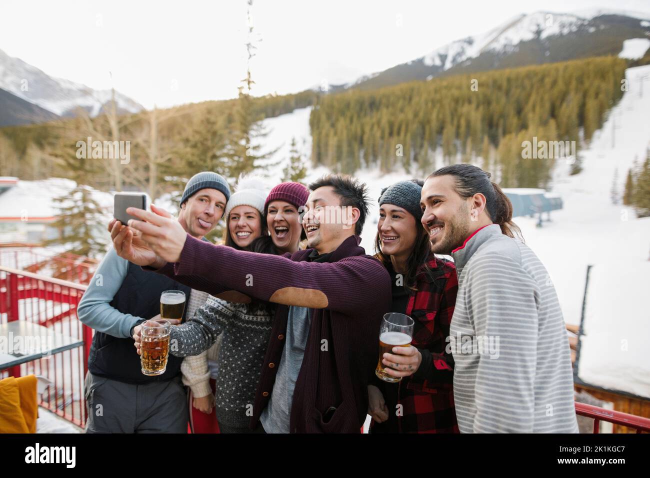 Glückliche Freunde von Skifahrern, die Selfie machen und Bier auf dem Balkon des Skigebiets trinken Stockfoto