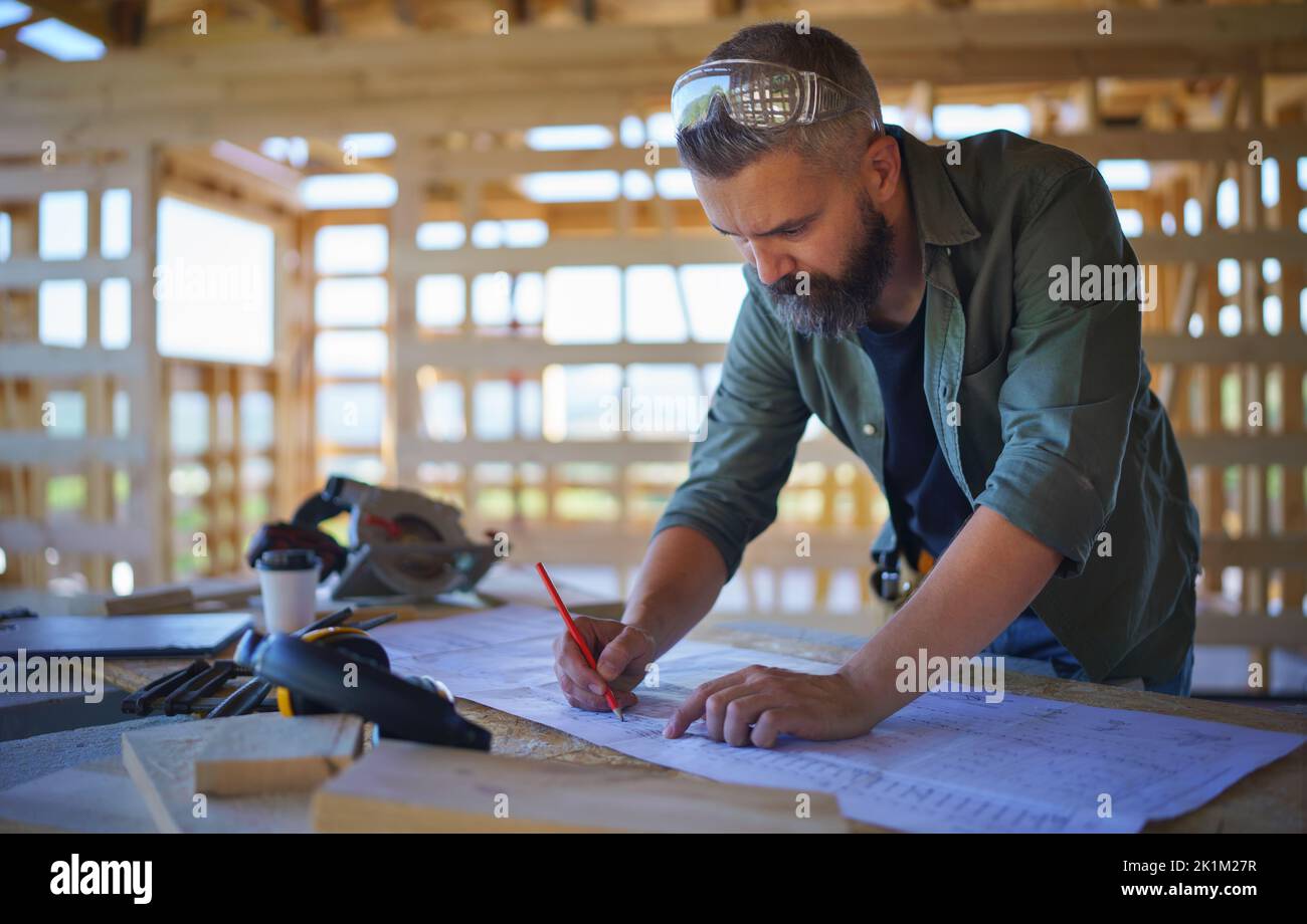 Bauarbeiter zeichnen und prüfen Blaupausen, diy umweltfreundliche Häuser Konzept. Stockfoto