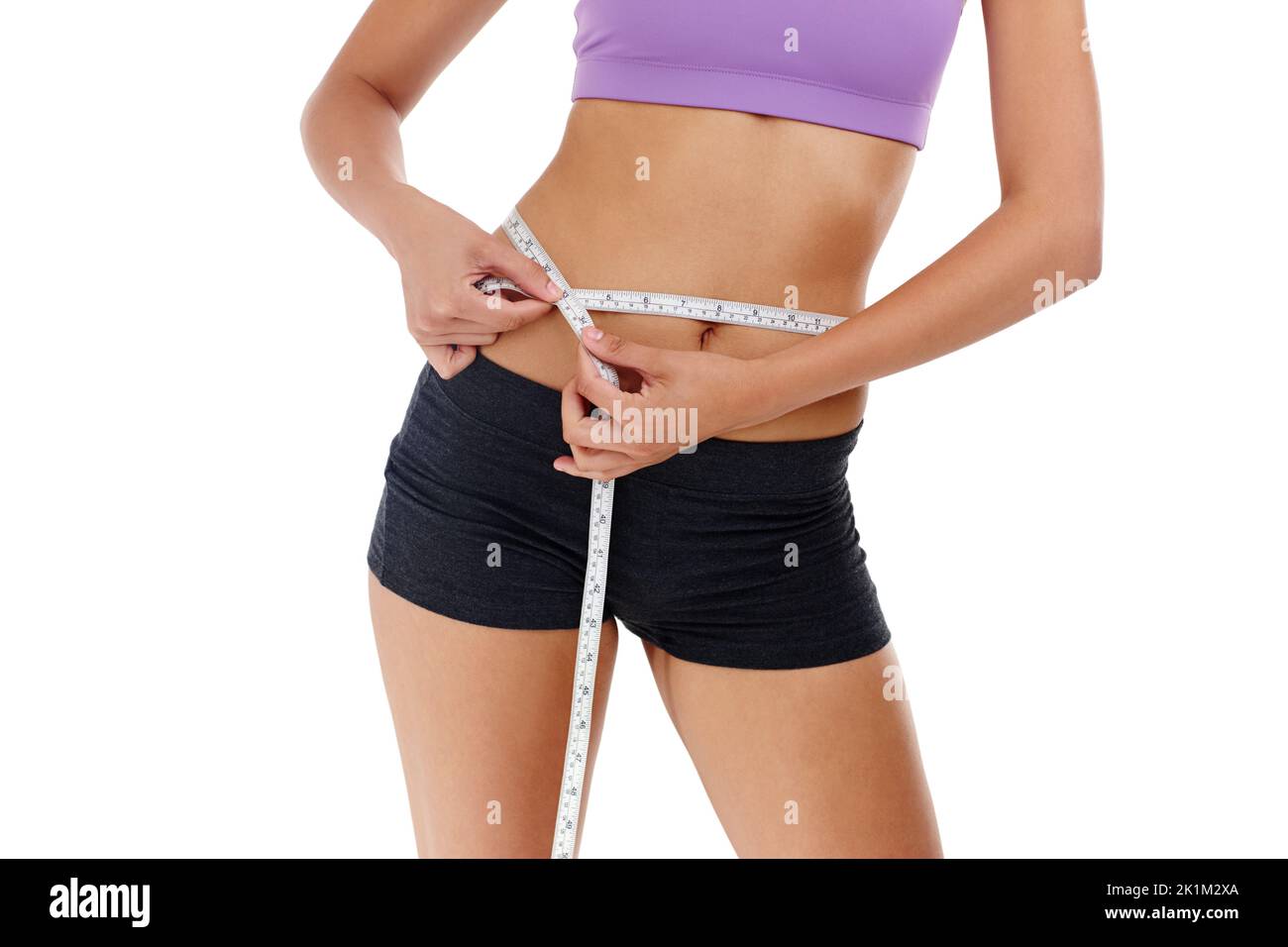 Was ist Ihre Taille Ziel. Eine unkenntlich Frau in Turnhalle Kleidung Messung ihrer Taille. Stockfoto