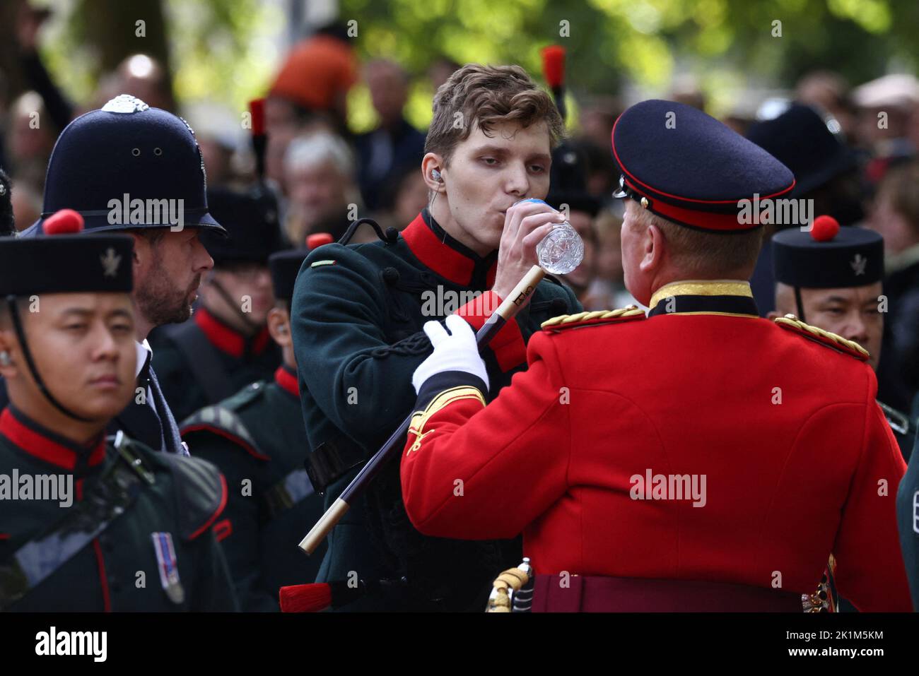 Ein Mitglied der Band trinkt Wasser, nachdem es am Tag der staatlichen Beerdigung und Beerdigung der britischen Königin Elizabeth in London, Großbritannien, am 19. September 2022 medizinische Hilfe erhalten hat. REUTERS/Tom Nicholson Stockfoto