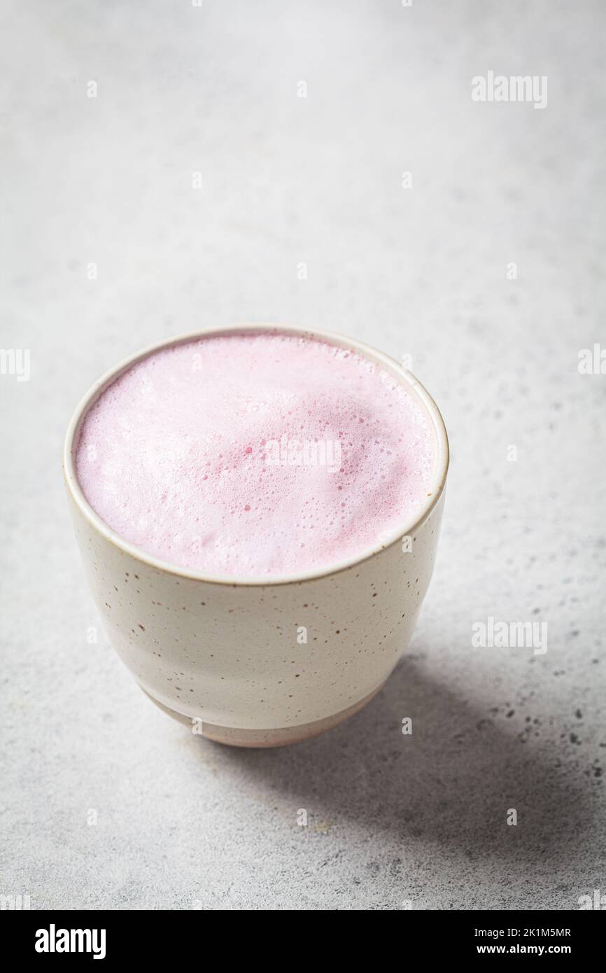 Rosa Blume Mond Milch in einem weißen Becher. Ayurveda-Getränk, gesunder Lebensstil, Heilmittel gegen Schlaflosigkeit. Stockfoto