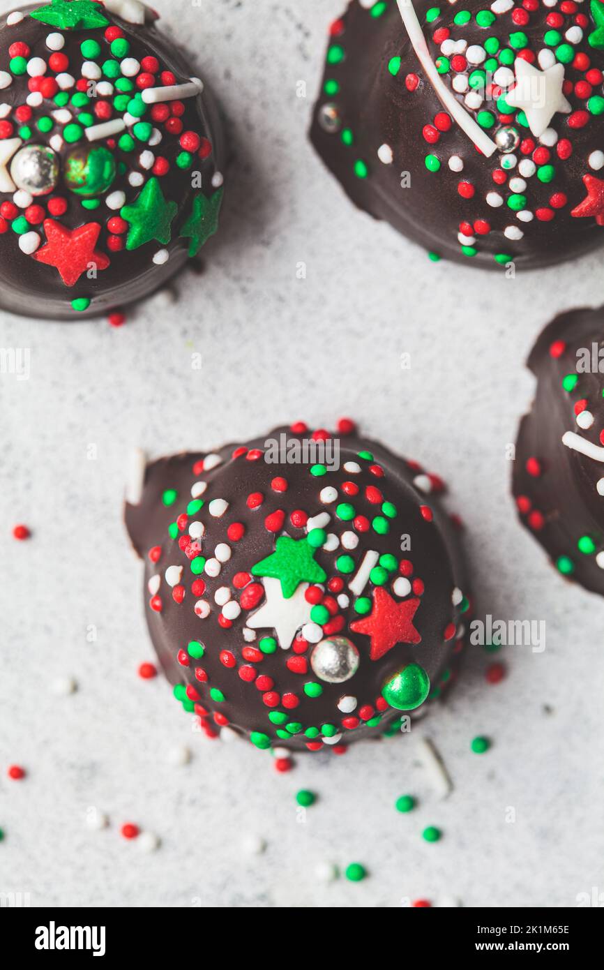 Weihnachten handgemachte Schokoladenkugeln mit Weihnachtsstreuseln, Nahaufnahme. DIY Weihnachtsgeschenk, Dessert Rezept. Stockfoto