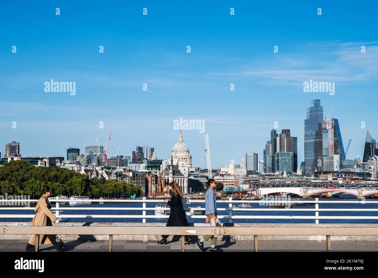 London, Vereinigtes Königreich - September 17 2022: Menschen, die auf der Waterloo-Brücke spazieren, Blick auf Canary Wharf London City und Saint Paul's Cathedral Stockfoto