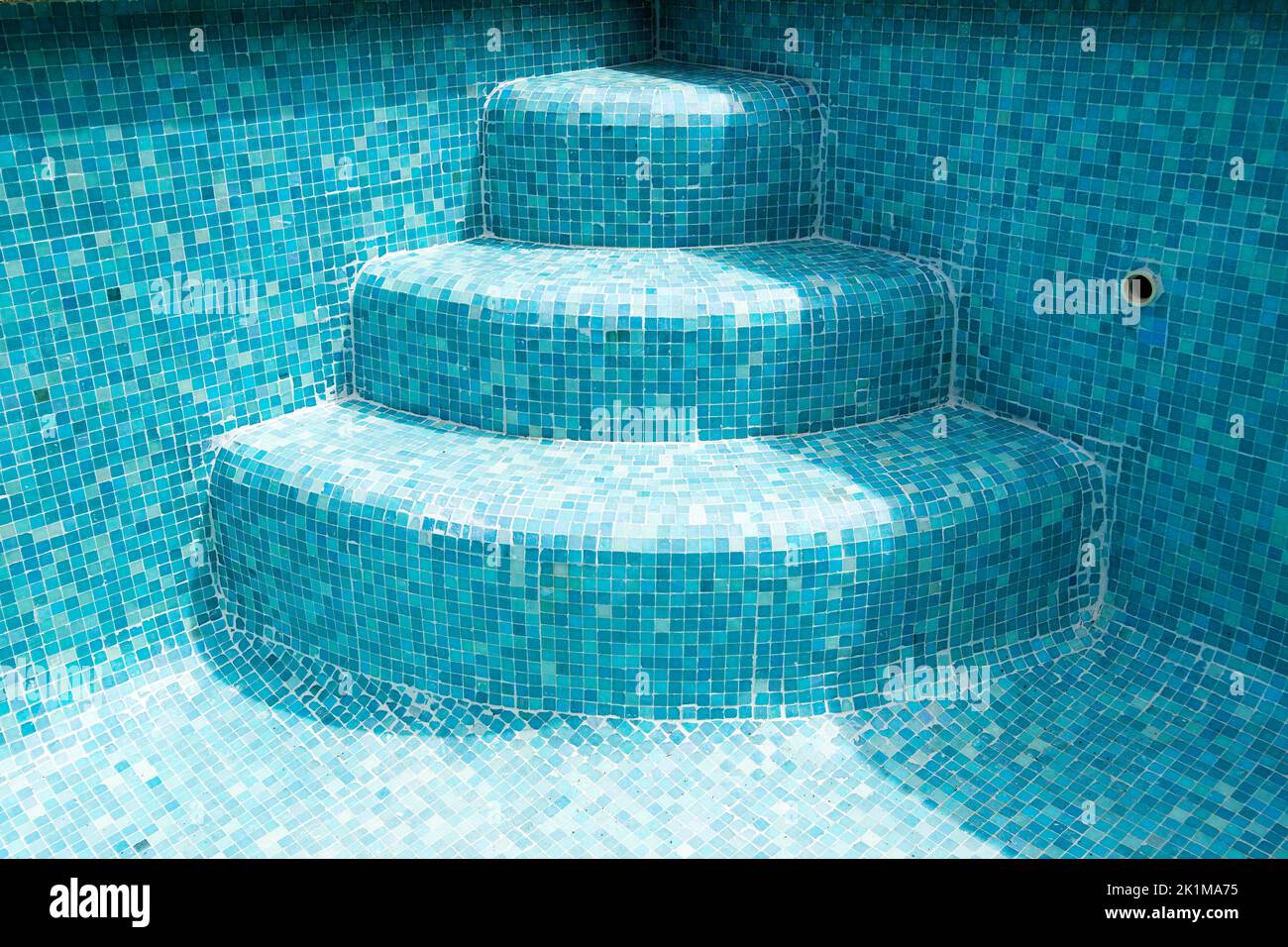 Der Pool ist eine Treppe in einen leeren Mosaikpool Stockfoto