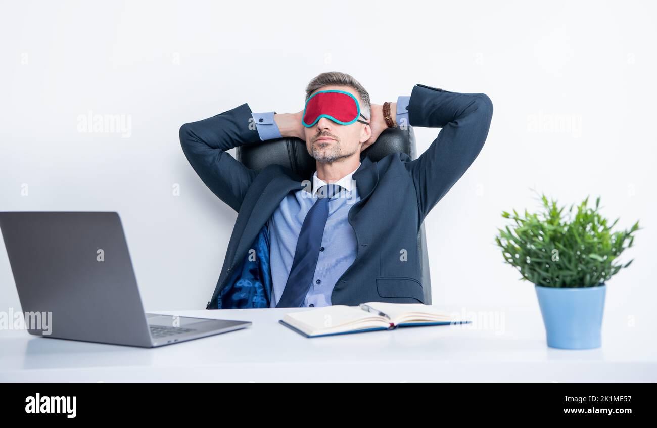 Müde Unternehmer entspannen in Schlafmaske am Arbeitsplatz Stockfoto