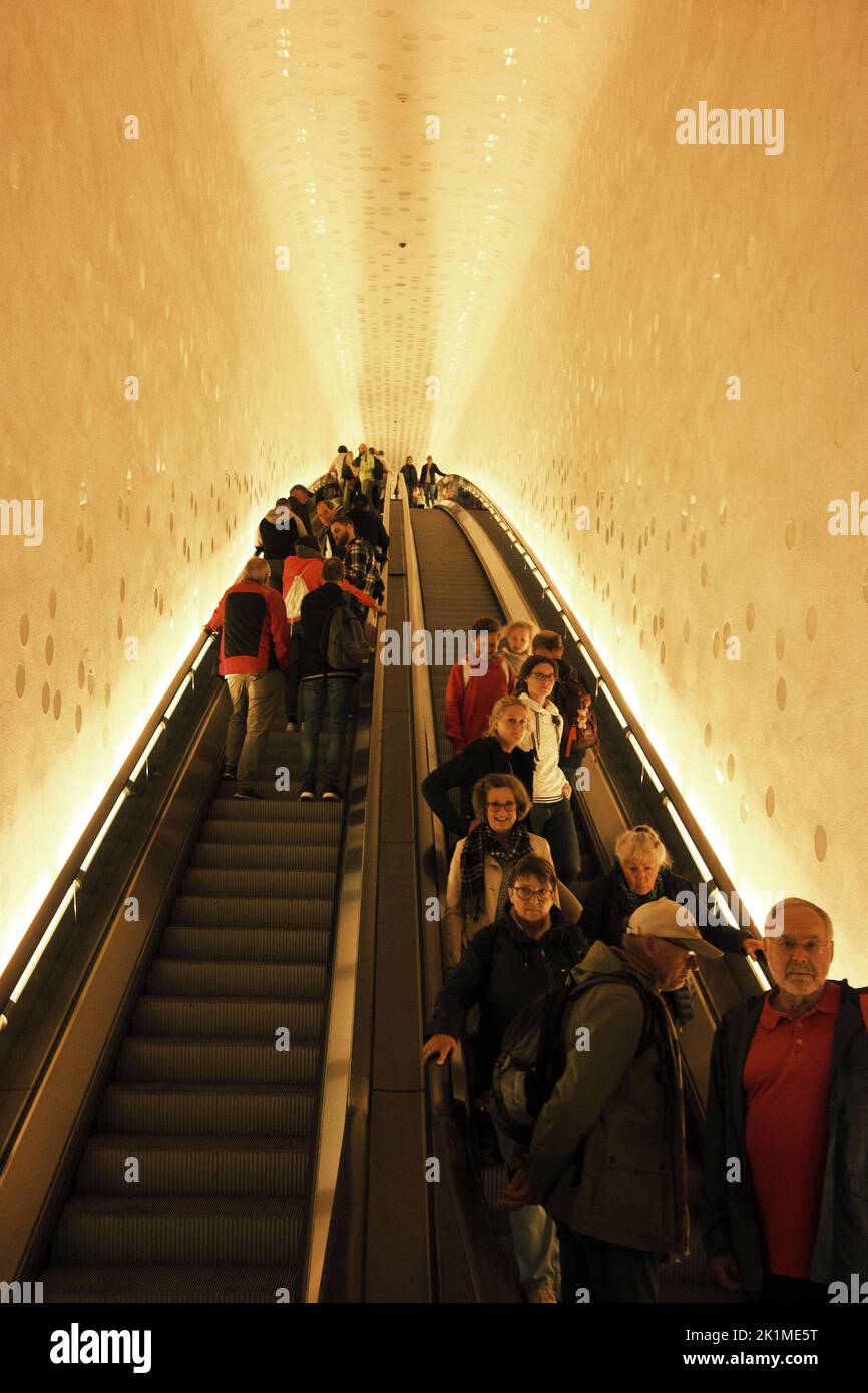 Die vertikale Ansicht von Menschen, die auf der Treppe einer geschwungenen Rolltreppe stehen Stockfoto