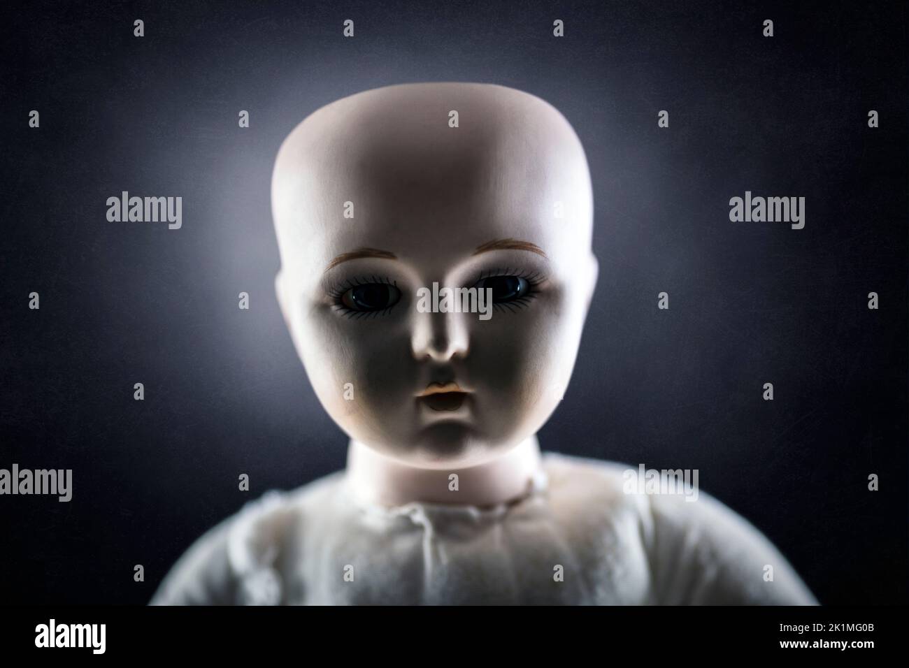 Gruseliges Puppengesicht auf dunklem Hintergrund Stockfoto