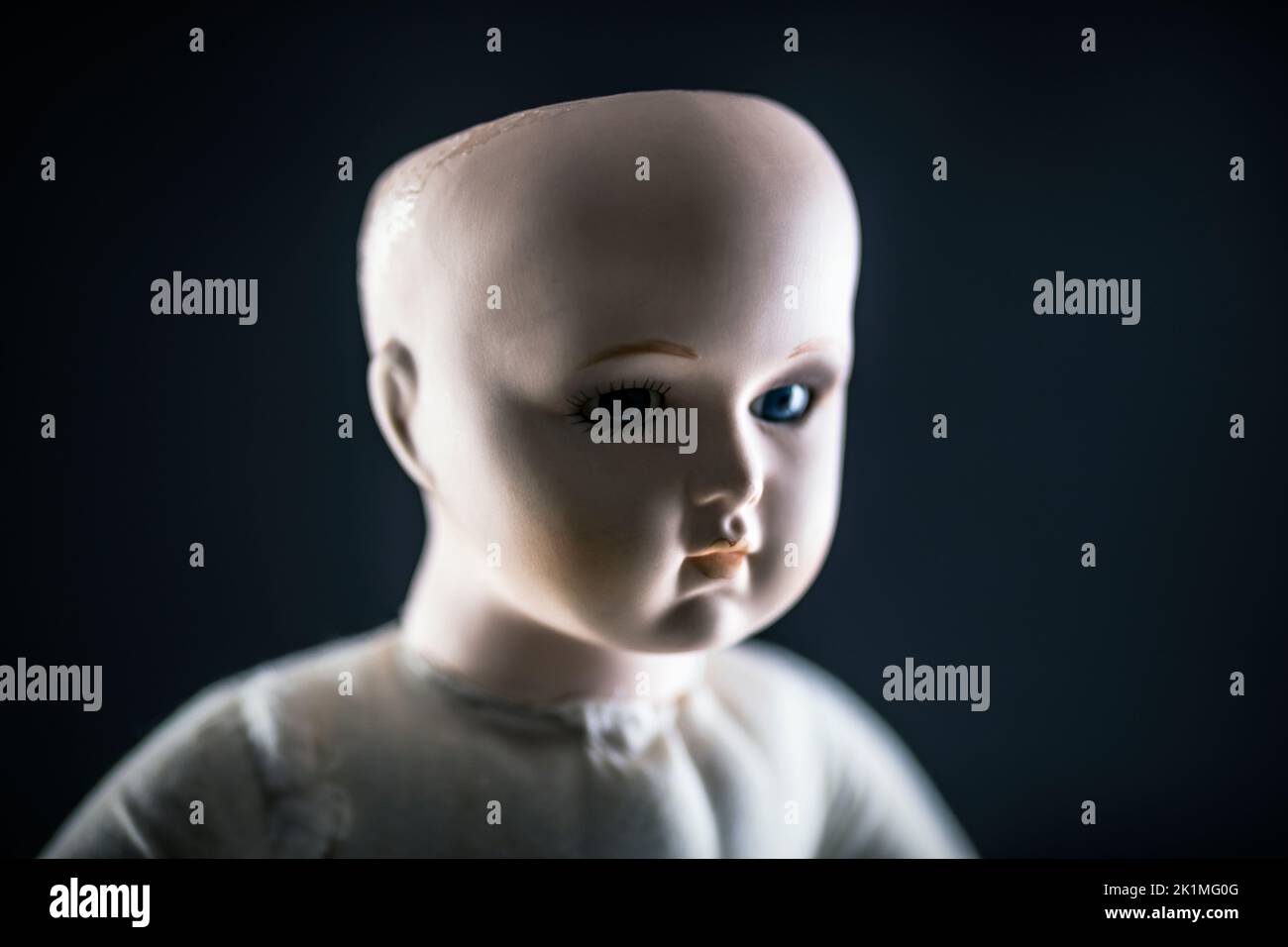 Gruseliges Puppengesicht auf dunklem Hintergrund Stockfoto