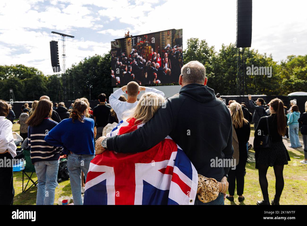 London, Großbritannien. 19. September 2022. Zwei Menschen umarmen sich im Hyde Park, während sie das Begräbnis von Königin Elizabeth II von den Großbildschirmen aus sehen.Quelle: Massimiliano Donati/Alamy Live News Stockfoto