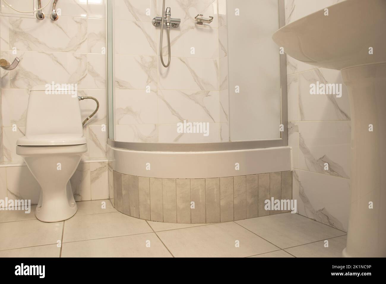 Toilettenschüssel und Duschkabine in einer Wohnwohnung in der Ukraine in hellen Farben, Bad, Interieur Stockfoto