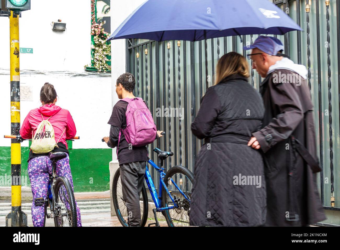 Bogota Kolumbien,Carrera 24,Teenager Teenager Teenager Teenager Teenager Jugendliche Jugend Fahrrad Fahrräder Fahrrad fahren Fahrräder,Wandern Regenschirm Mann Männer männlich Frau Frauen weiblich Stockfoto