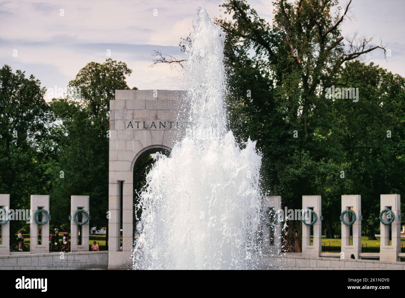 Wasser schießt von einem Brunnen im Zentrum des World war II Memorial in Washington, D.C. nach oben. Der atlantische Eingang zum Denkmal ist sichtbar. Stockfoto