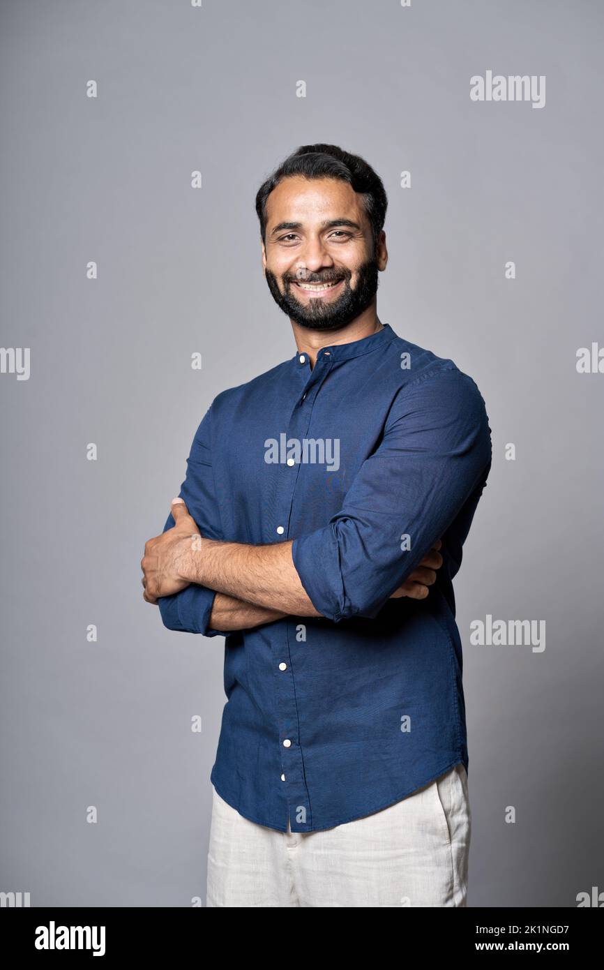 Lächelnder indischer Geschäftsmann, isoliert auf grauem, vertikalem Porträt. Stockfoto