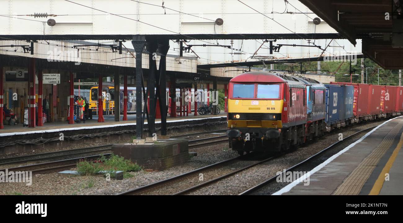 Zweiköpfige elektrische DB Cargo-Loks der Klasse 90 im Containerzug, der den Bahnhof Lancaster auf der West Coast Main Line durchquert, 14.. September 2022. Stockfoto