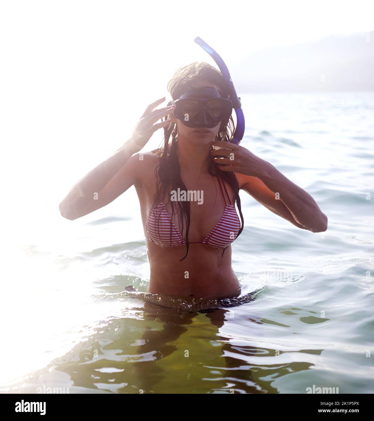 Eine junge Frau, die eine Schwimmbrille im Wasser trägt. Stockfoto