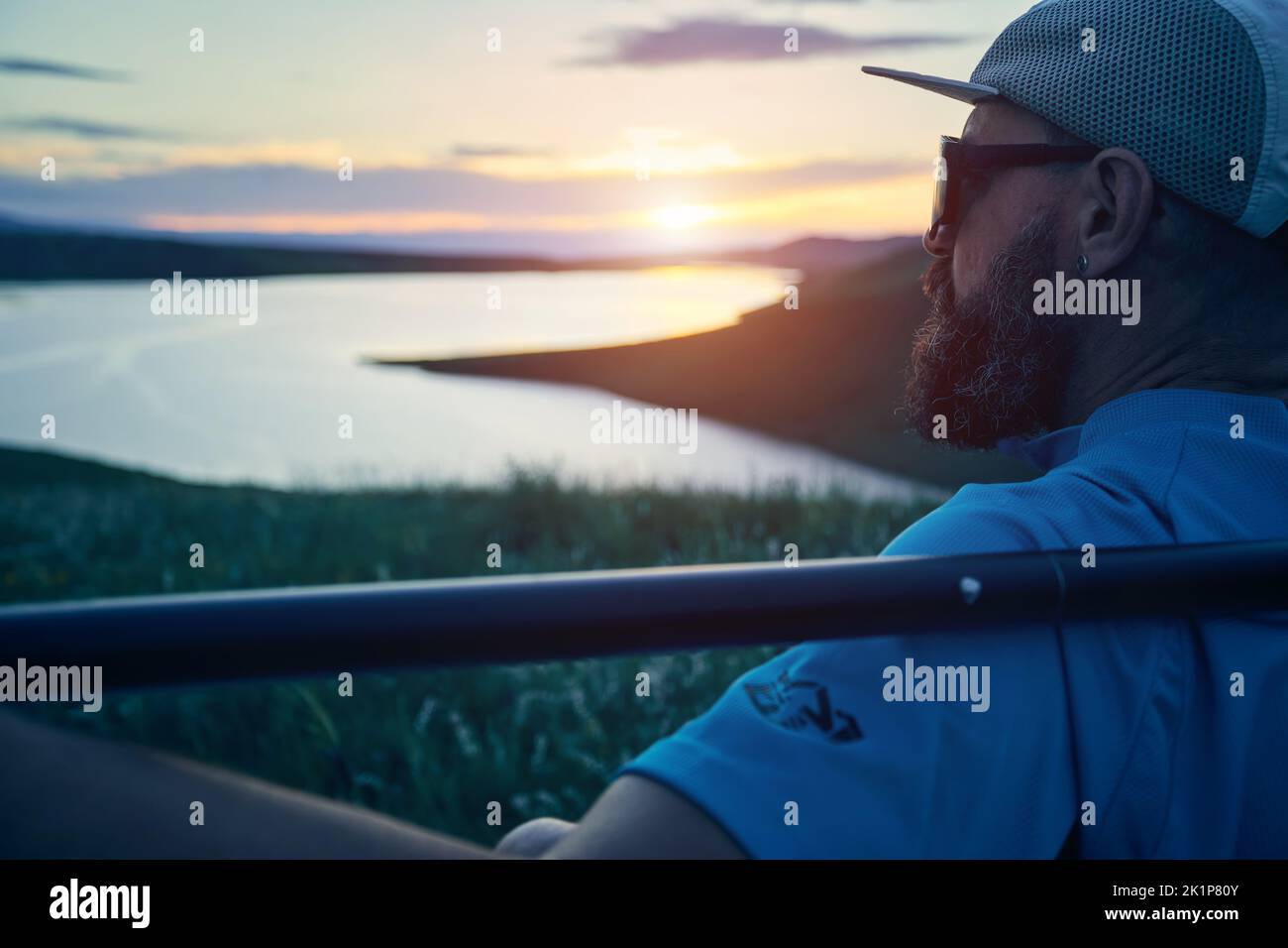 Porträt eines bärtigen Mannes in Silhouette mit SUP-Paddel in der Nähe des Sees bei Sonnenuntergang in Kasachstan. Stand Up Paddle Boarding Outdoor aktiv Erholung i Stockfoto