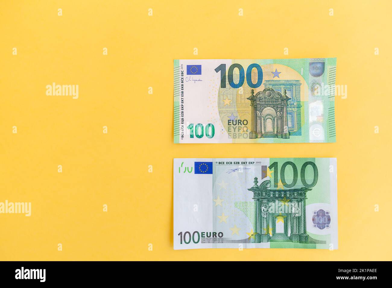 Alte und neue Banknoten von hundert Euro auf gelbem Hintergrund. Stockfoto