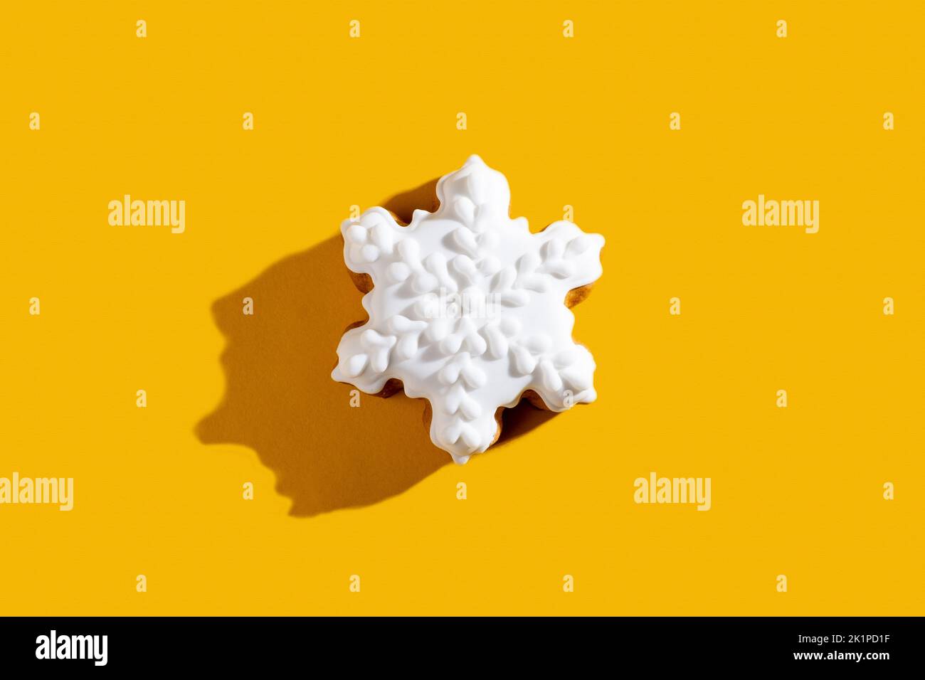 Winterdessert. Festliche Bäckereikunst. Weihnachtskekse Ornament. Weißer Lebkuchen Schneeflocke Cookie mit Glasur isoliert auf orange leeren Raum zurück Stockfoto