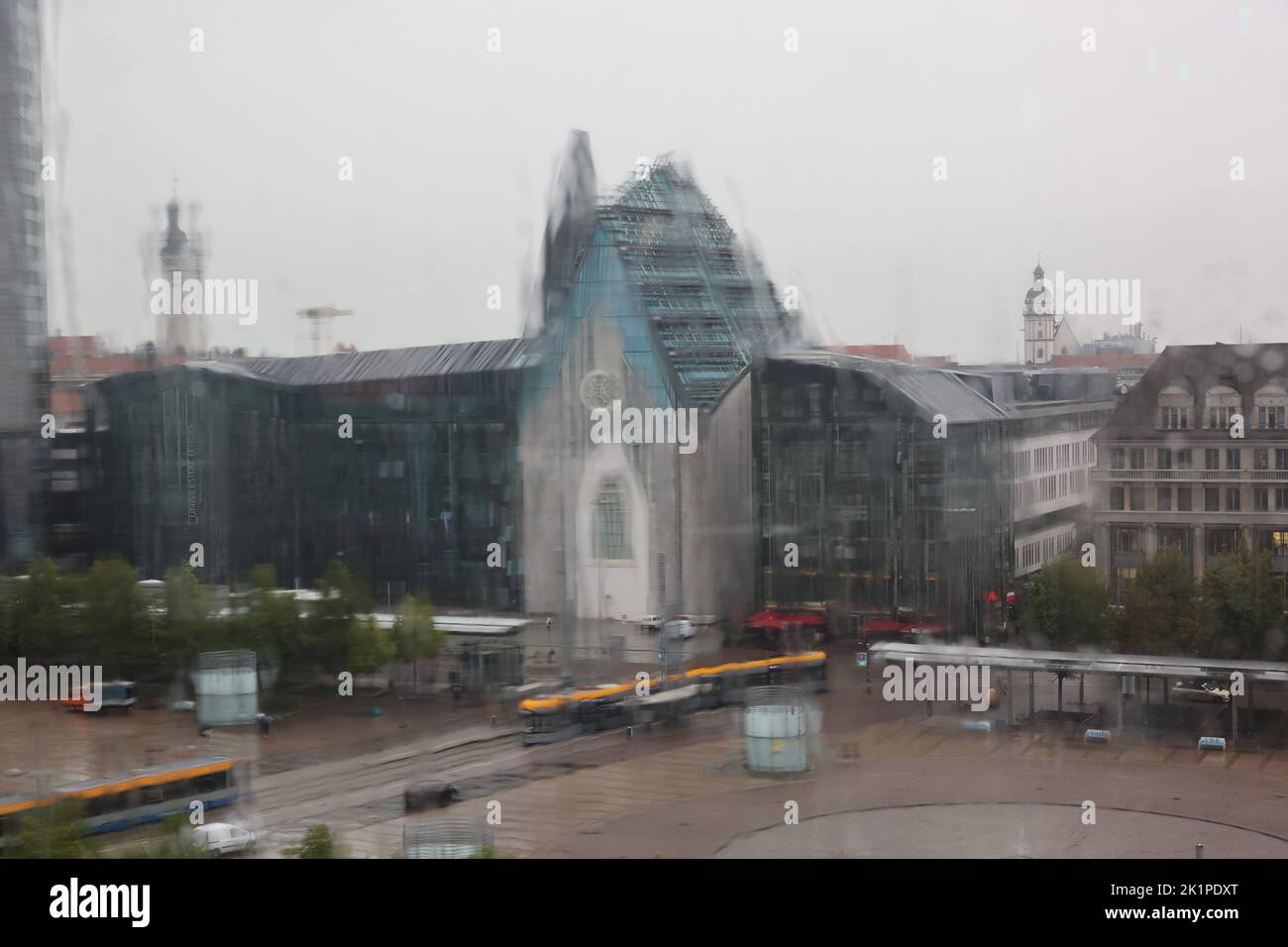 Blick durch eine verregnete Glasscheibe auf die Universität mit Paulinum und der Universitätskirche St. Pauli am Augustusplatz, Sachsen, Deutschland. Stockfoto