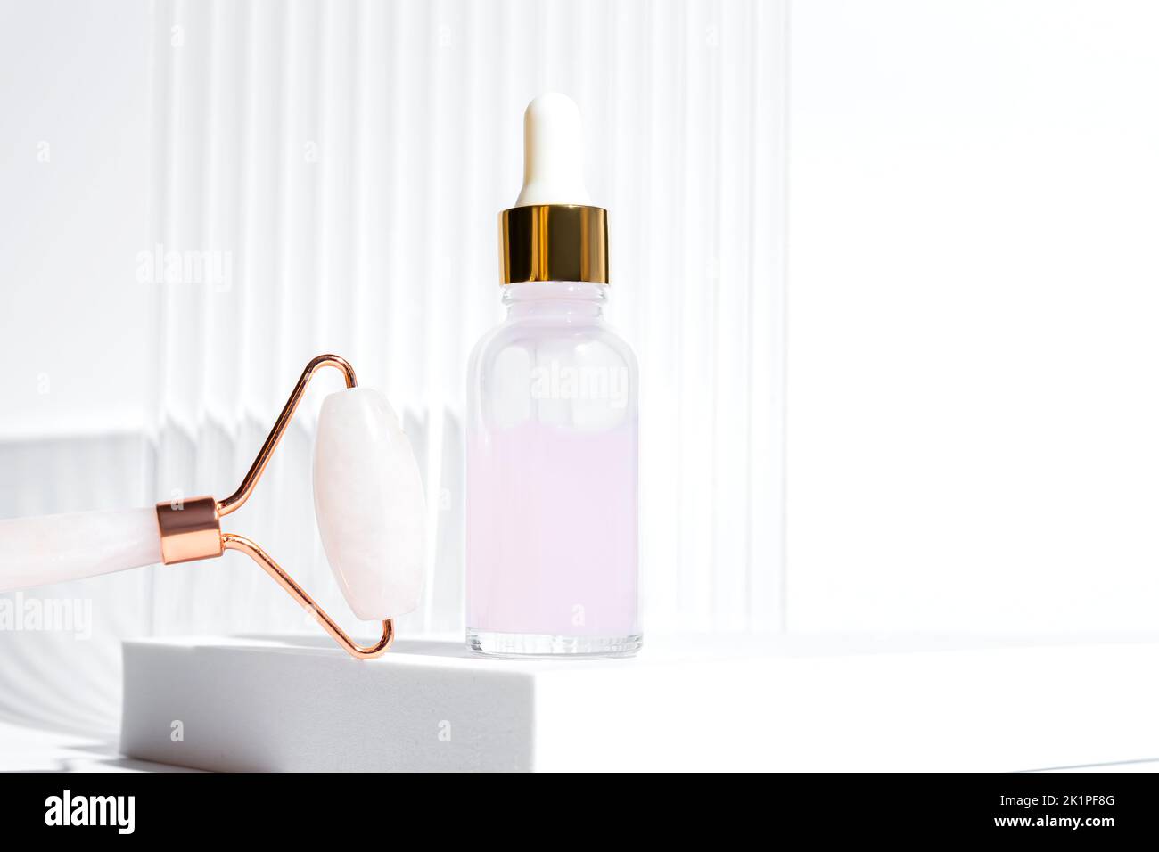 Kosmetisches Rose ätherisches Öl und Rosenquarz Roller Gesichtsmassager Gua-Sha Stein für die Gesichts-Schönheitsmassage zu Hause. Hautpflege und Gesichtsbehandlung conce Stockfoto