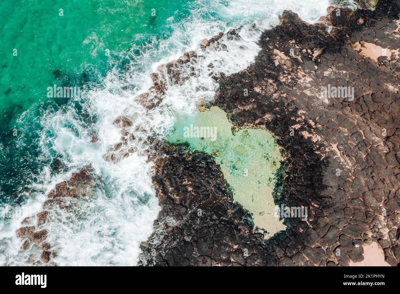 Luftaufnahme des Küstenfelsenpools und der Meereswellen, die über das Felsschelf fließen Stockfoto