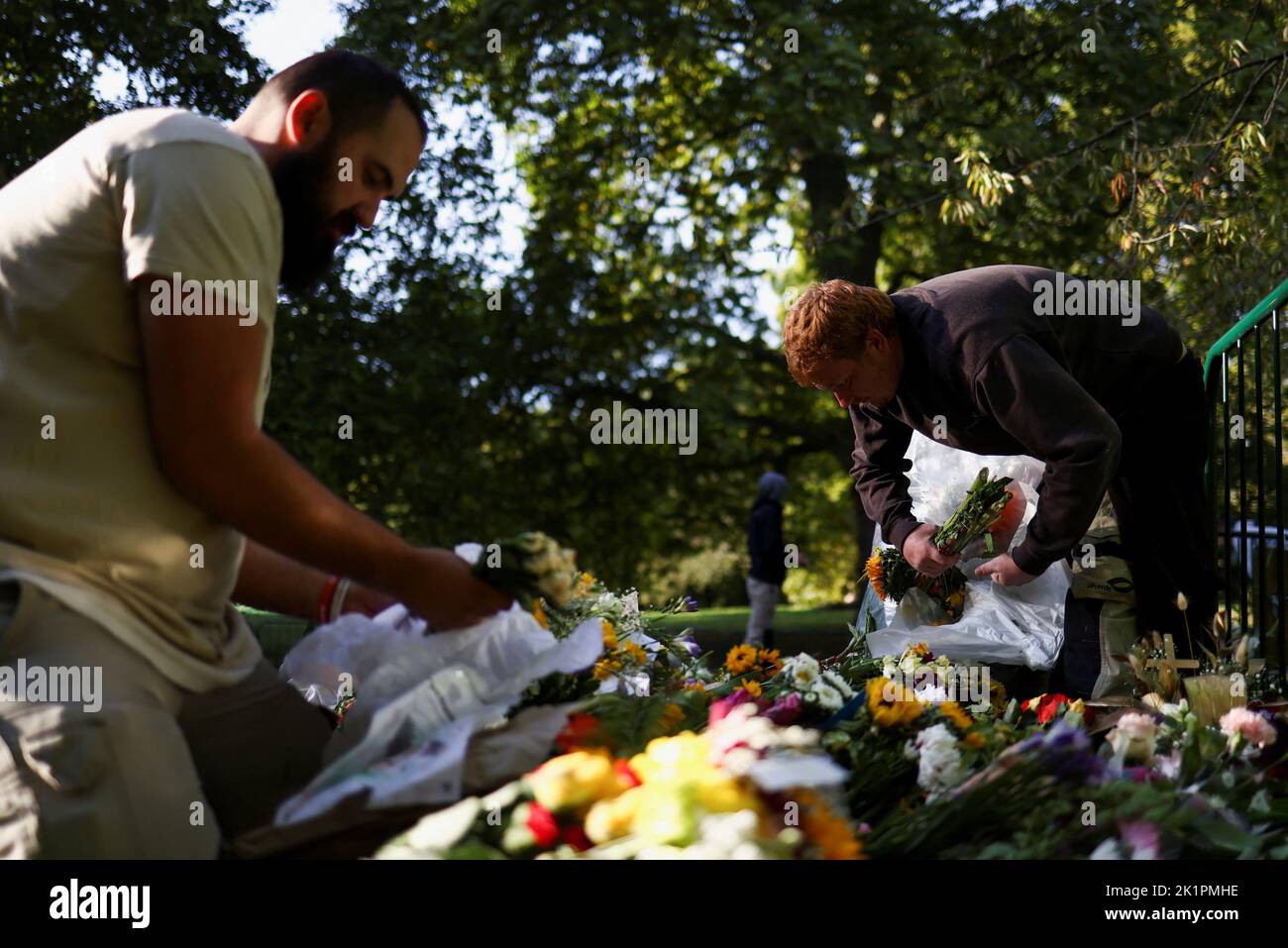 Freiwillige entfernen nach der Beerdigung der britischen Königin Elizabeth im Green Park in London, Großbritannien, am 20. September 2022 Verpackungen von Blumengebeten. REUTERS/Tom Nicholson Stockfoto