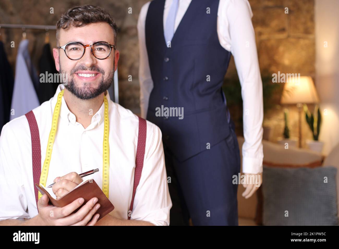 Modedesignerin notiert auf traditionellem Notizblock Stockfoto