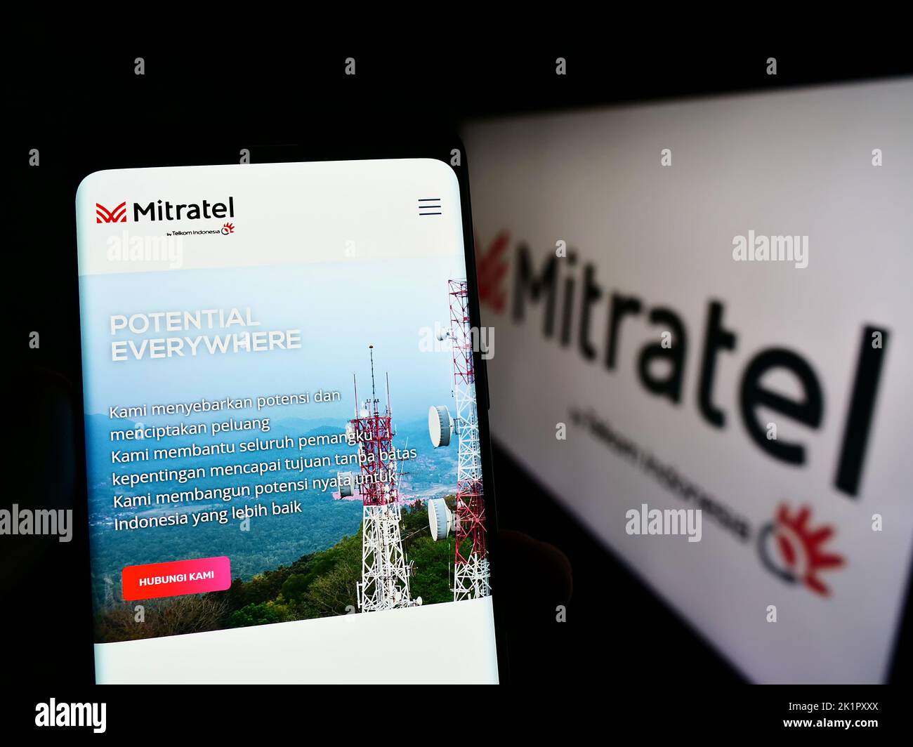 Person mit Mobiltelefon auf der Website von PT Dayamitra Telekomunikasi Tbk. (Mitratel) auf dem Bildschirm vor dem Logo. Konzentrieren Sie sich auf die Mitte des Telefondisplays. Stockfoto