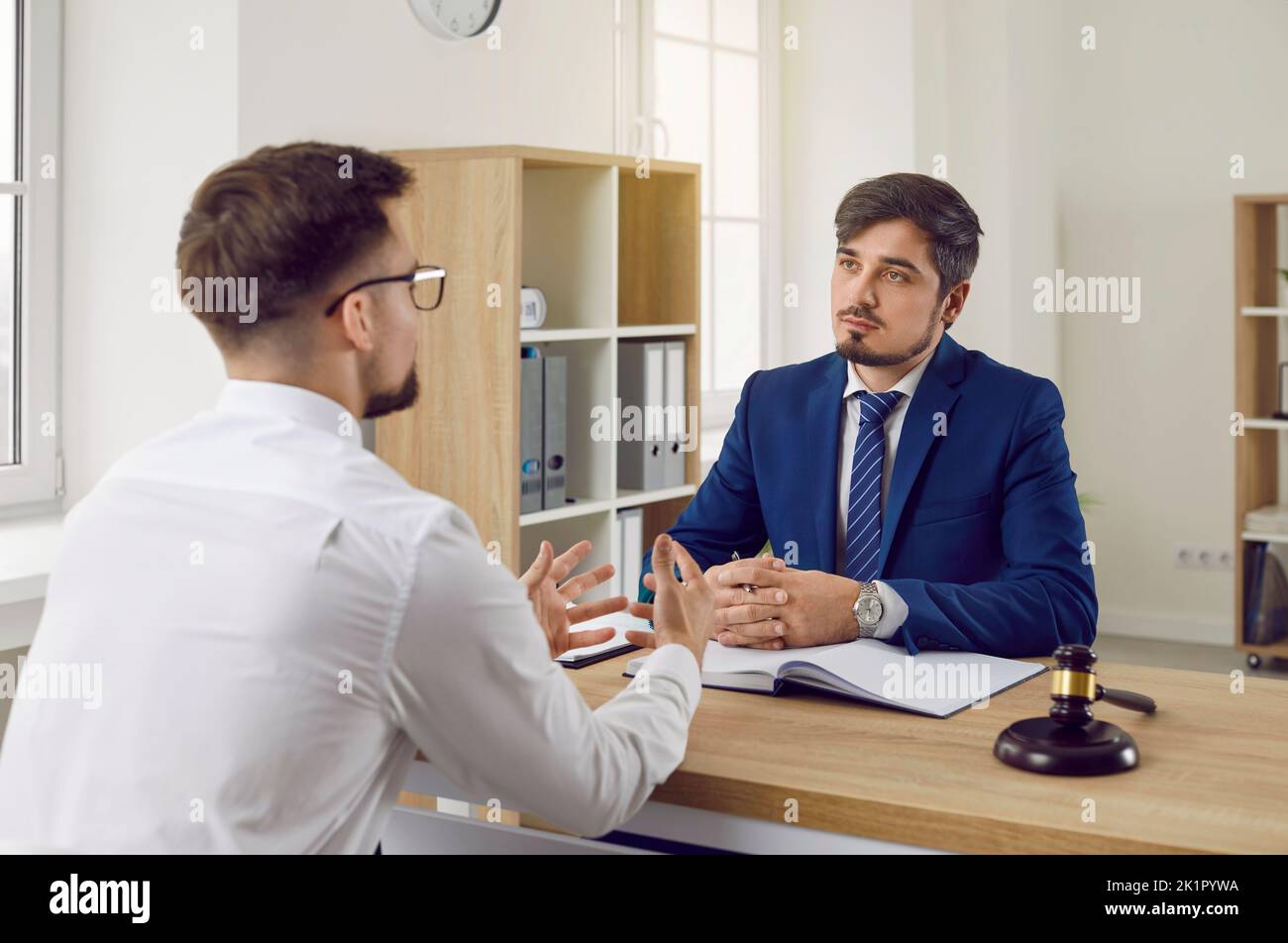 Ein professioneller Anwalt oder Anwalt hört seinem Mandanten zu, der über sein Problem spricht Stockfoto