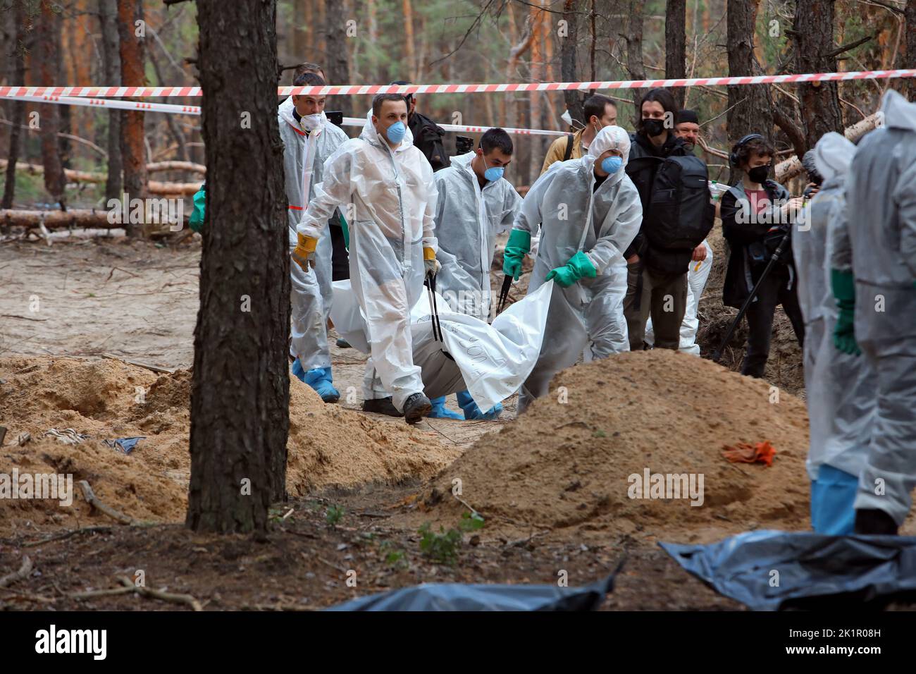 IZIUM, UKRAINE - 19. SEPTEMBER 2022 - Experten tragen einen Leichensack mit den Überresten einer der Leichen von Izium-Bewohnern, die von russischen Besatzern getötet wurden Stockfoto