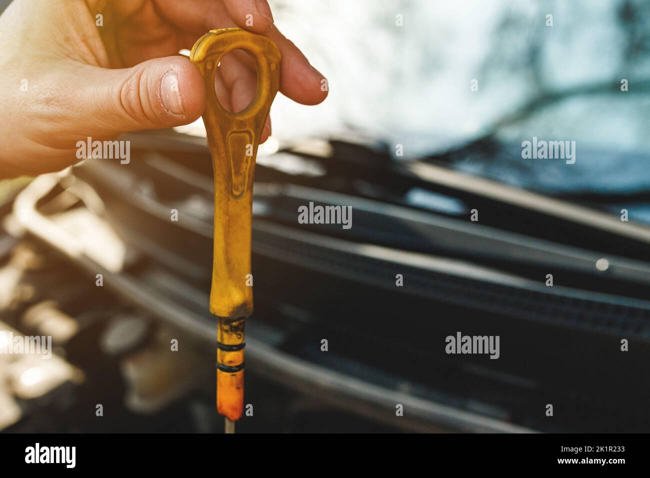 Schmutziger gelber Griff von einem Automotor-Messstab in der Hand Stockfoto