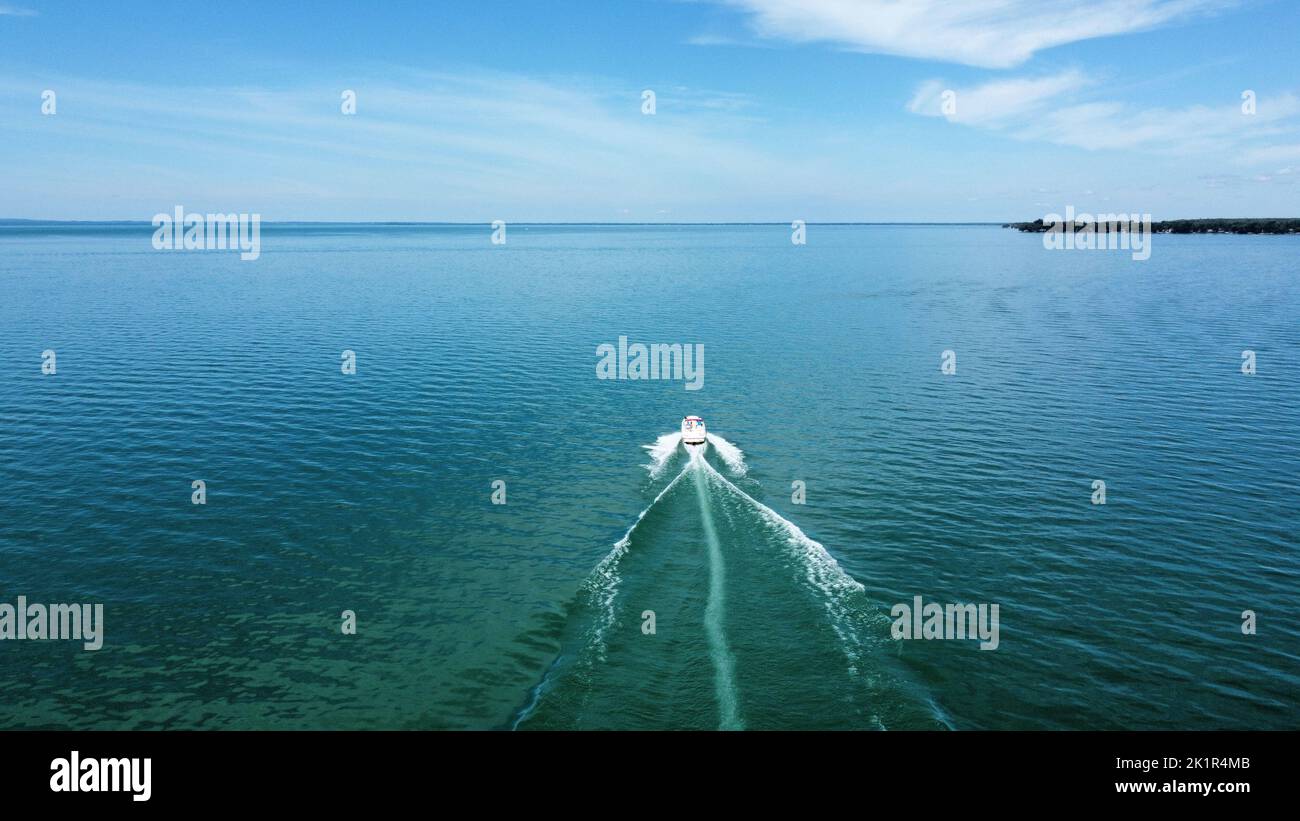 Eine Drohnenansicht eines Motorbootes auf dem Lake Simcoe, Ontario mit blauem Himmel darüber Stockfoto