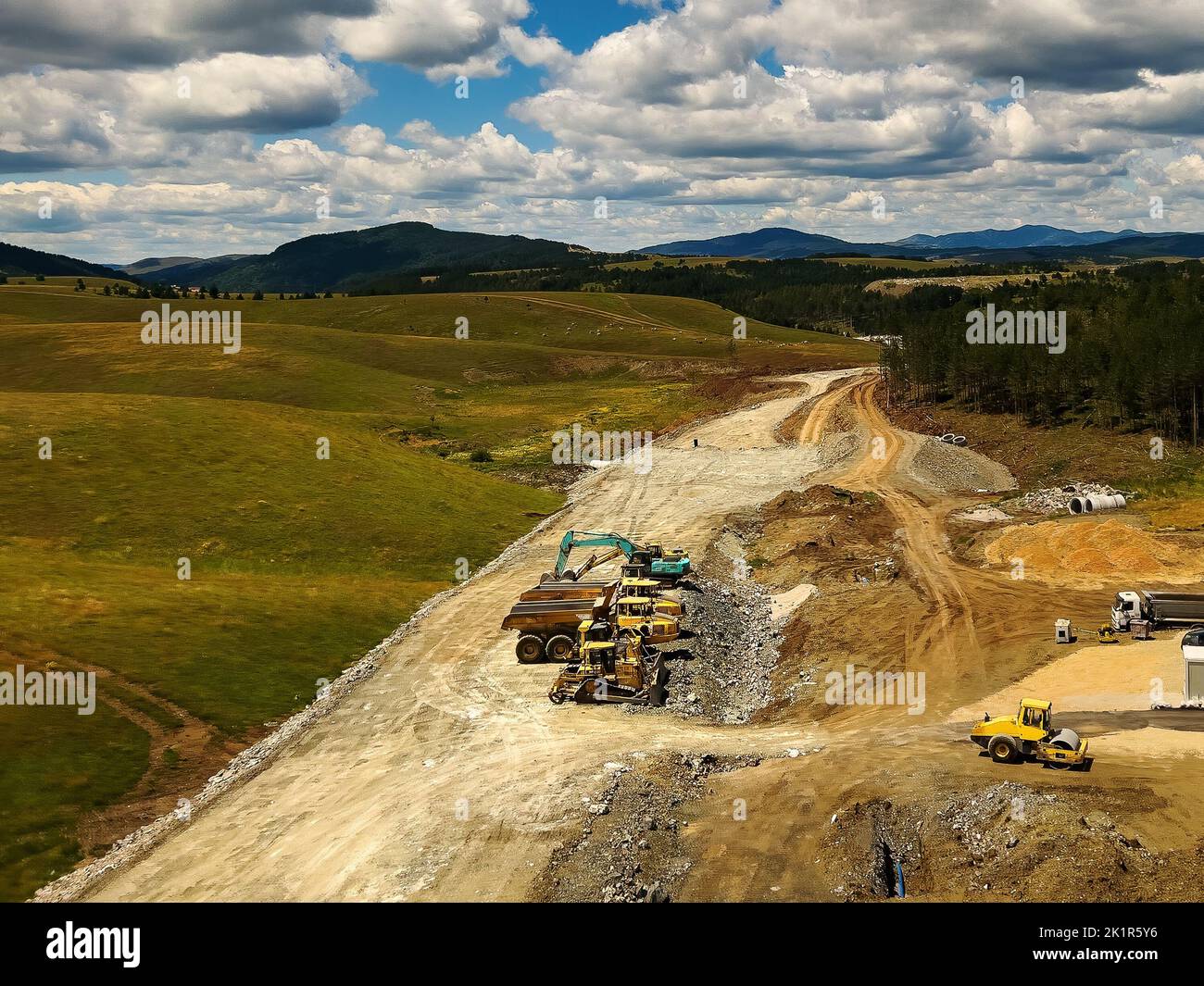 Straßenbau und schwere Industriemaschinen in Zlatibor, Luftaufnahme von Drohne pov am sonnigen Sommertag Stockfoto