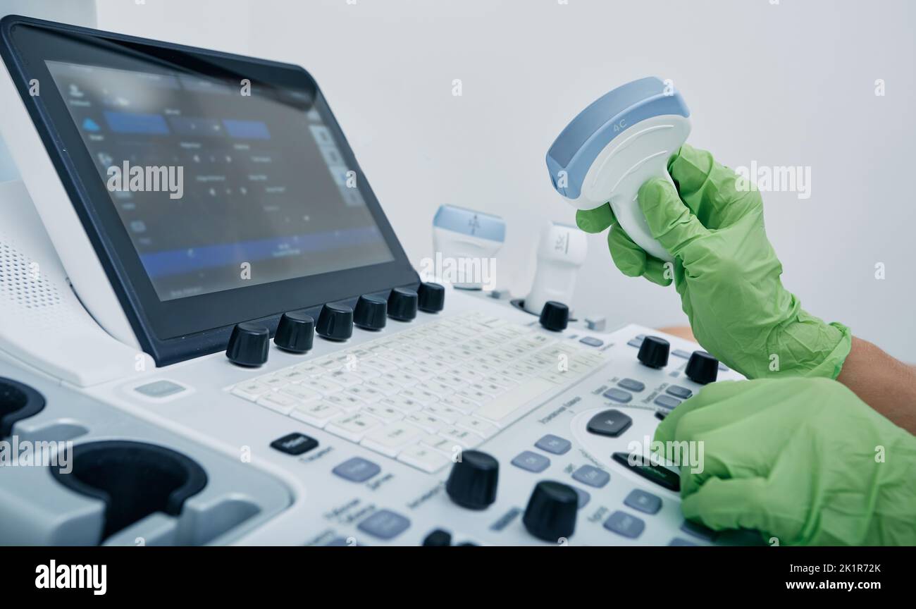 Sonographie. Medizinischer Ultraschallwandler in der Hand des Arztes, Nahaufnahme in der Nähe des Ultraschallgeräts in der medizinischen Klinik Stockfoto