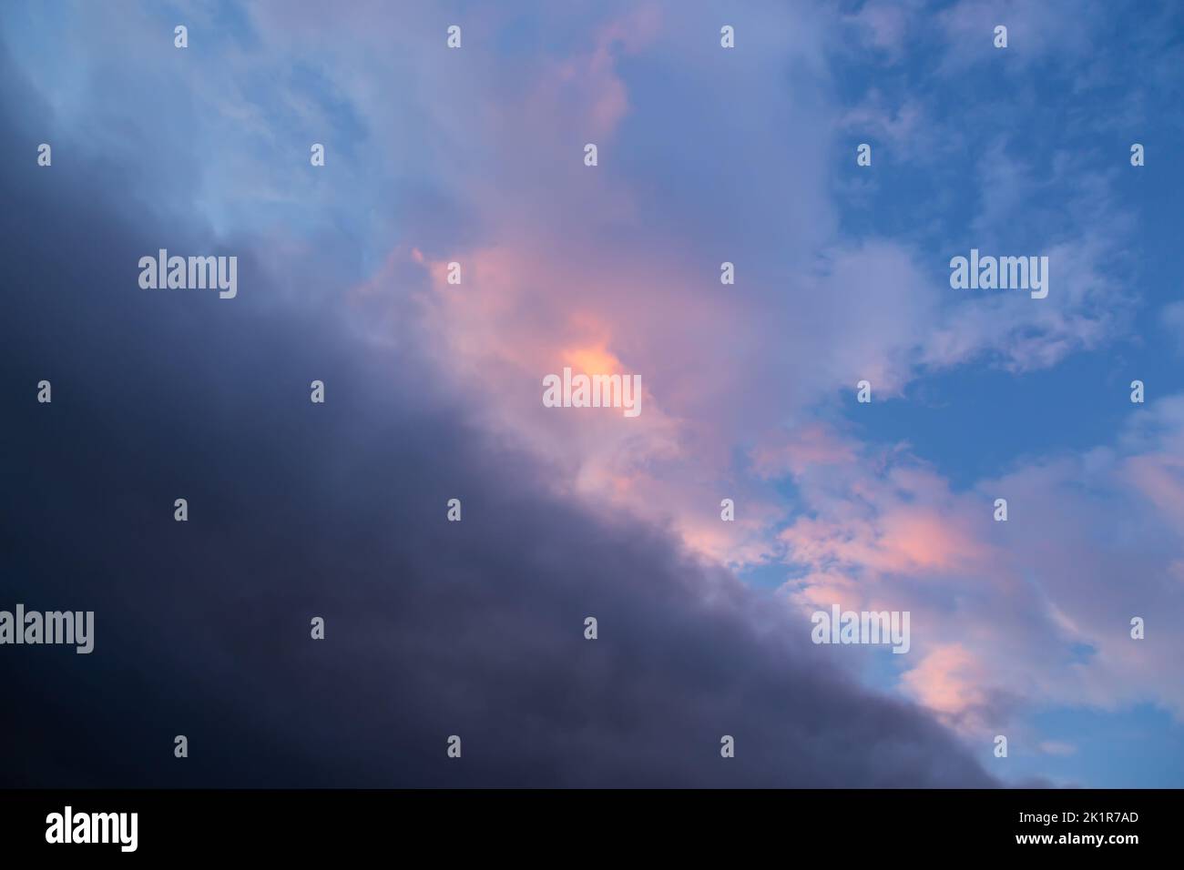 Stürmischer dramatischer Himmel mit Wolken bei Sonnenuntergang, diagonal geteilt Stockfoto