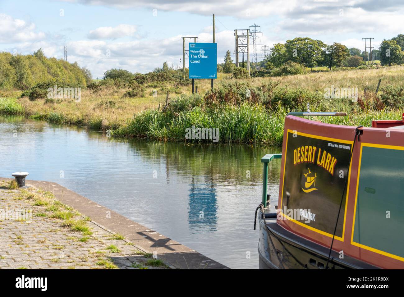 Ein Hausboot auf dem Union Canal neben einem Schild für schottische Kanäle in Falkirk, Schottland, Großbritannien. Stockfoto