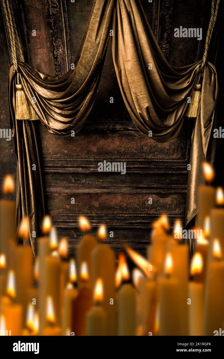 Baldachin aus goldenen Vorhängen mit einer Reihe brennender Kerzen davor Stockfoto