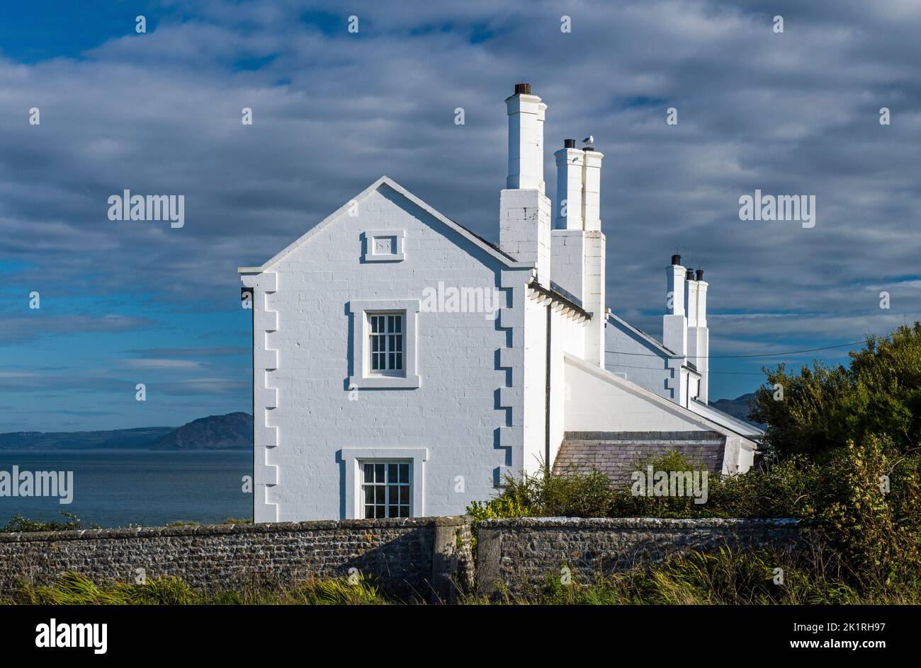 Weiß getünchte Küstenwache Cottages in Trwyn Penmon Anglesey an einem sonnigen Septembernachmittag. Sie sind jetzt Ferienhäuser. Stockfoto