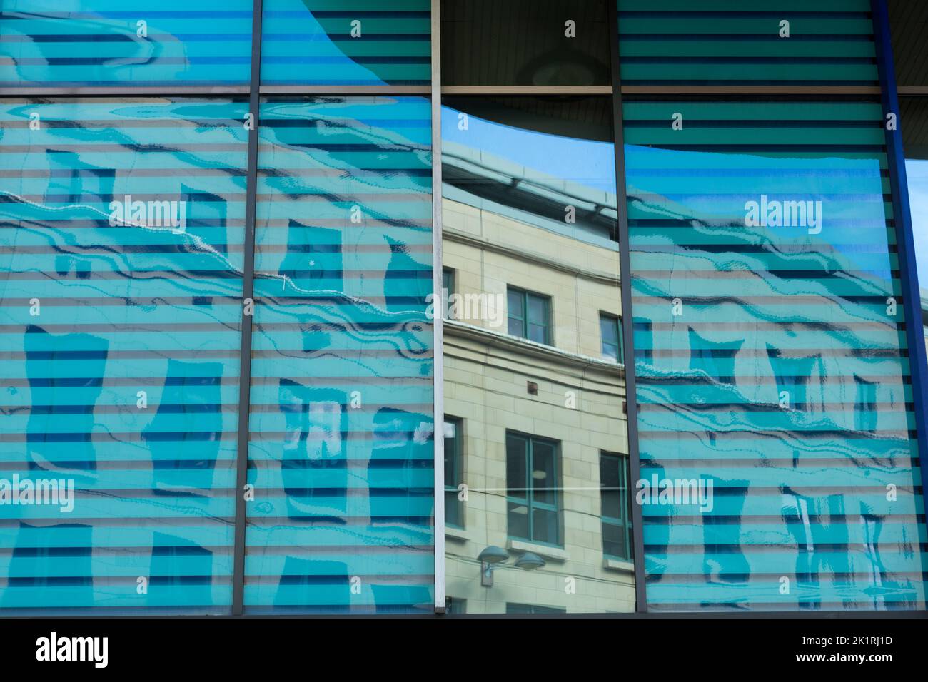 Spiegelung eines Bürogebäudes aus Glas auf einem Gebäude in Exchange Crescent, Edinburgh, Schottland Stockfoto