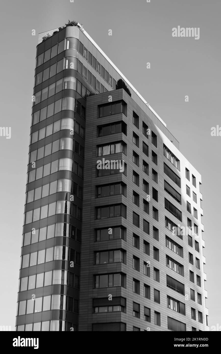 Eine vertikale Graustufenaufnahme eines modernen Hochhauses im Düsseldorfer Medienhafen Stockfoto